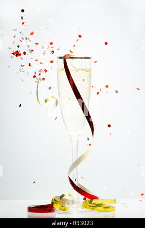 Concept représenté de confettis célébration autour d'un verre de Champagne Banque D'Images