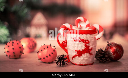 L'abri de la laine en tissu brodé avec mug sur la table en bois de cerf avec mug mandarines et un bonbon Banque D'Images