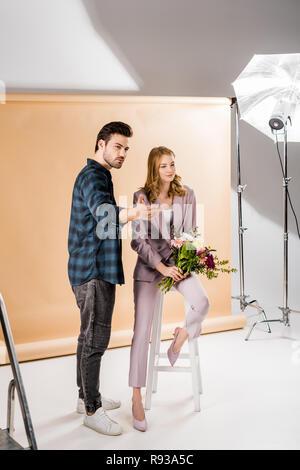 Le jeune photographe parlant avec beau modèle féminin en photo studio Banque D'Images