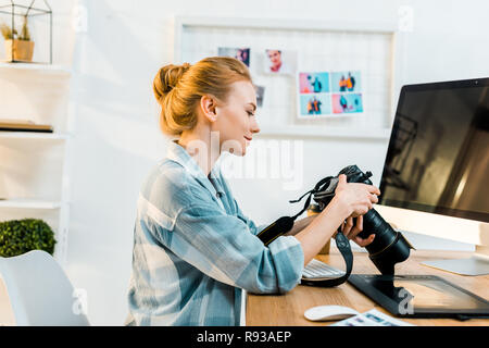 Vue latérale du jeune femme photographe travaillant avec l'appareil photo à l'office de tourisme Banque D'Images