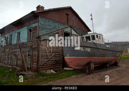 Petit bateau de pêche abandonnés, CEP, en face d'une maison à l'abandon dans une localité rurale, Dalniye Zelentsy, péninsule de Kola Banque D'Images