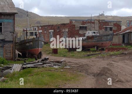 Petits bateaux de pêche abandonnés, CEP, en face de maisons abandonnées dans une localité rurale, Dalniye Zelentsy, péninsule de Kola Banque D'Images