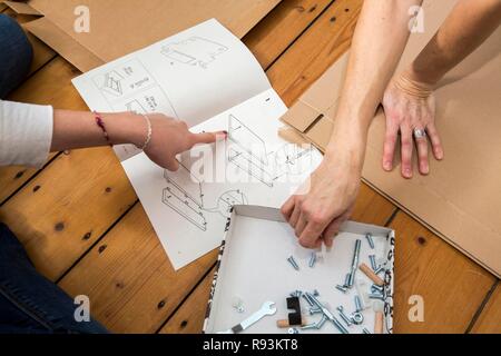 Mère et fille qui travaille ensemble pour former un lit double dans la chambre, lit fille jeux de montage, Allemagne Banque D'Images