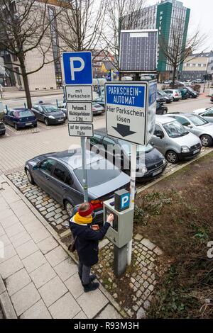 Femme de l'achat d'un ticket de parking à énergie solaire à partir d'un distributeur automatique de billets de stationnement, un parking public du centre-ville, Essen Banque D'Images