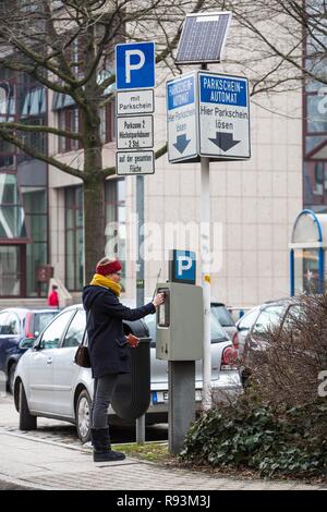 Femme de l'achat d'un ticket de parking à énergie solaire à partir d'un distributeur automatique de billets de stationnement, un parking public du centre-ville, Essen Banque D'Images