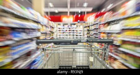 Un panier vide entre l'étagère lignes dans le supermarché avec effet de flou. Dans le monde d'utilisation | Banque D'Images