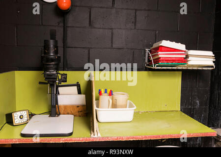 Une chambre noire est mis en place pour l'école secondaire en cours de photographie avec un style ancien agrandisseur noir et blanc, un timing clock et de produits chimiques pour le développement. Banque D'Images