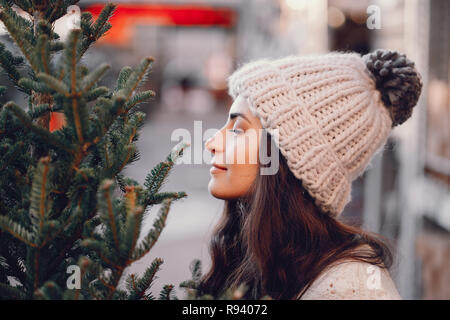 Brunette mignon dans un chandail blanc avec arbre de Noël Banque D'Images