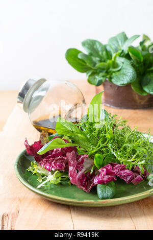 L'alimentation saine notion Mélange de salade de légumes en plaque verte sur fond bois with copy space Banque D'Images