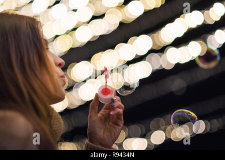 Femme s'amusant faisant des bulles de savon dans la nuit de la partie Banque D'Images