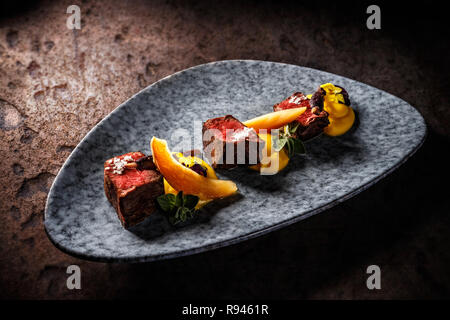 Filet de chevreuil avec purée de patate douce, carotte pourpre blanchies, confiture de coing avec du vin Banque D'Images