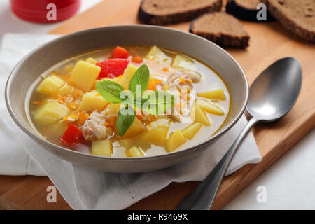 Soupe au poulet avec légumes et le pain de seigle sur une table rustique Banque D'Images