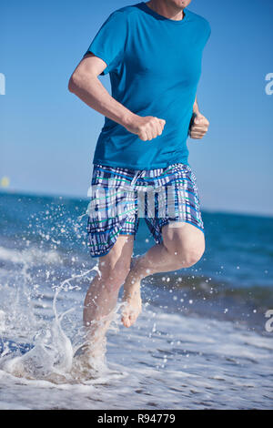 Barefoot man pendant le jogging sur une plage Banque D'Images