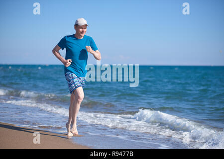 Barefoot man pendant le jogging sur une plage Banque D'Images