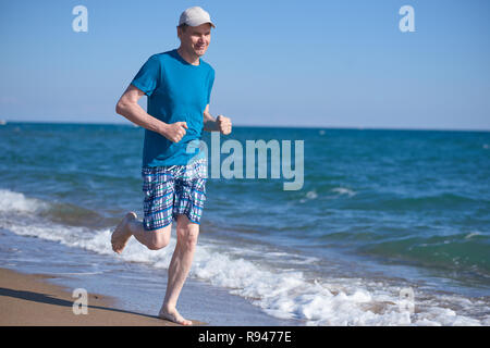 Barefoot man pendant le jogging sur une plage Banque D'Images