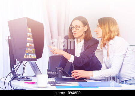 Portrait de femme photographe et à l'ordinateur, le choix d'images dans le bureau Banque D'Images