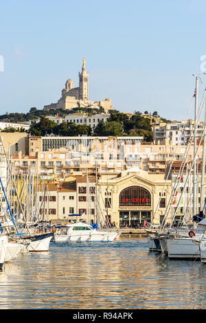 "La Criée" salle de théâtre, l'ancienne halle de marché de poisson, sur le Vieux Port à Marseille, France, avec la basilique Notre-Dame de la garde en haut de la colline. Banque D'Images