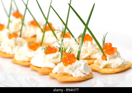 Craquelins salés avec du fromage à la crème et caviar rouge Banque D'Images