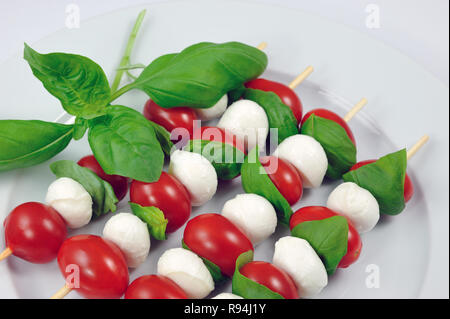 Quatre baguettes fraîches avec tomates cerises, mozzarella et basilic italien Banque D'Images