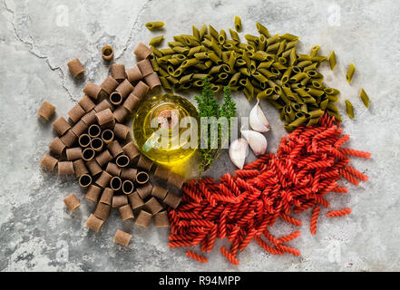 Multicolor pâtes sans gluten avec des ingrédients dont elle est faite sur une table en pierre Banque D'Images