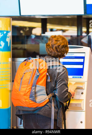 TOKYO, JAPON - 7 novembre, 2017 : Femme avec sac à dos orange au comptoir d'enregistrement de l'aéroport. Vue arrière. Avec selective focus Banque D'Images