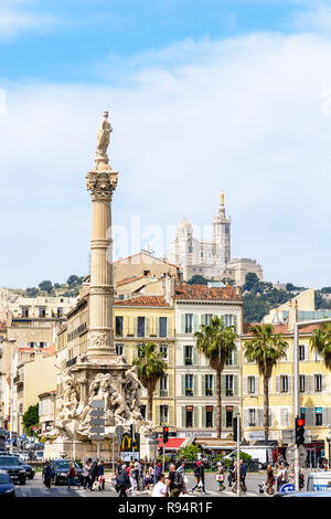 La Place Castellane à Marseille, France, avec la fontaine Cantini et sa colonne et basilique Notre-Dame de la garde en haut de la colline. Banque D'Images