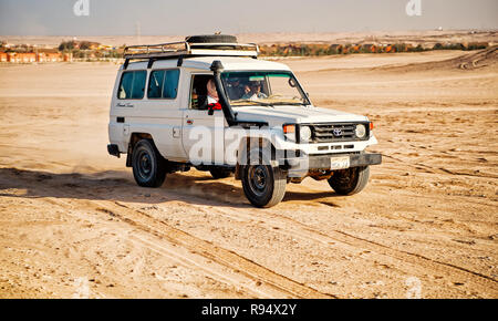 Hurghada, Egypte - 26 Février 2017 : blanc, Toyota Land cruiser, voiture japonaise ou jeep, véhicule tout terrain, la conduite sur les dunes de sable du désert, surface sur fond de ciel bleu. Loisirs de l'offroading Banque D'Images