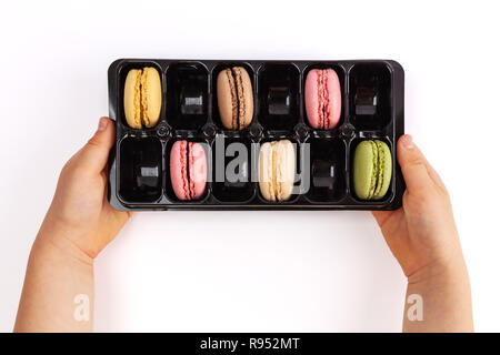 Enfant tenant avec ses macarons isolé sur blanc. Top View with copy space Banque D'Images