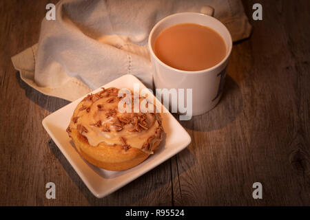 Tasse de thé avec un petit pain sucré Banque D'Images