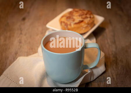 Tasse de thé avec un petit pain sucré Banque D'Images