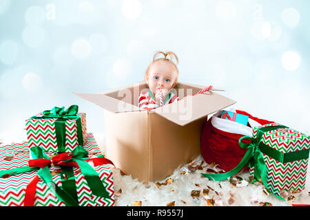 Mignon bébé fille 1 ans assis dans la case sur fond de Noël. Maison de vacances, célébration, kid concept Banque D'Images