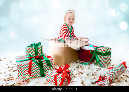 Mignon bébé fille 1 ans assis dans la case sur fond de Noël. Maison de vacances, célébration, kid concept Banque D'Images