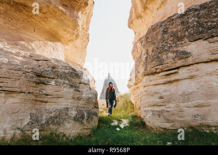 La femme se tient entre belles pierres et admire le paysage de Cappadoce en Turquie. Le paysage de la Cappadoce. Collines et un passage entre eux Banque D'Images