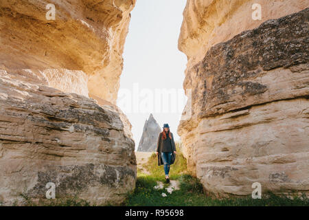 La femme passe entre les rochers et admire le paysage de Cappadoce, Turquie Banque D'Images