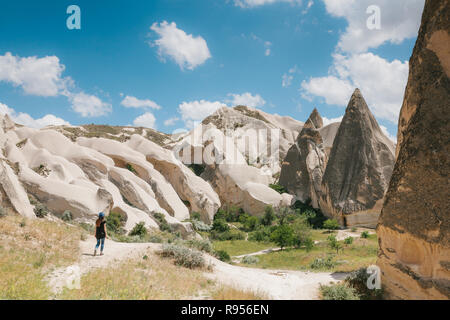 Une fille de tourisme promenades le long de la route à côté de la merveilleuse collines de la Cappadoce en Turquie et admire la beauté autour de. Le paysage de la Cappadoce Banque D'Images