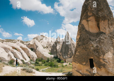 Une fille de tourisme promenades le long de la route à côté de la merveilleuse collines de la Cappadoce en Turquie et admire la beauté autour de. Le paysage de la Cappadoce Banque D'Images