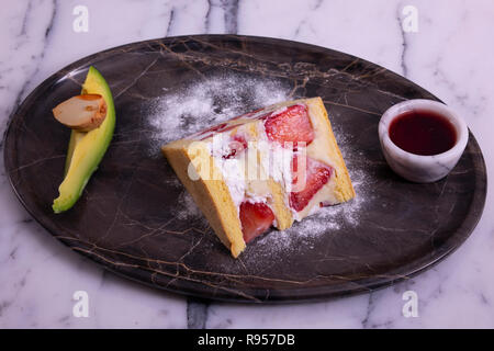 Gâteau aux fraises et poire alligator noir en plaque de marbre blanc sur la table de marbre Banque D'Images