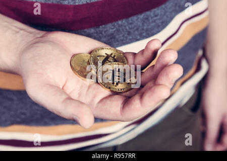 L'homme est maintenant cryptocurency bitcoin monnaie d'or dans sa main Banque D'Images