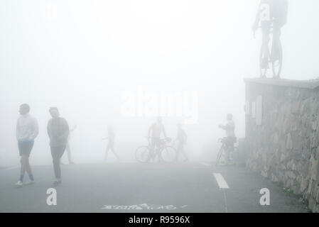 Les touristes à regarder la statue de Tour de France cycliste Octave Lapize au Col du Tourmalet dans un épais brouillard dans les Pyrénées, France Banque D'Images