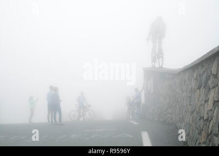 Les touristes à regarder la statue de Tour de France cycliste Octave Lapize au Col du Tourmalet dans un épais brouillard dans les Pyrénées, France Banque D'Images