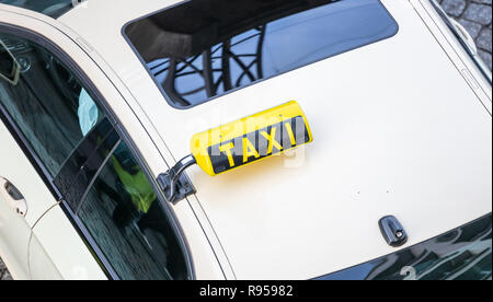 Vue de dessus d'un taxi blanc. Taxi jaune signe et reflet de la rue sur la vitre en verre. Vue de dessus, une partie de la voiture, l'espace. Banque D'Images