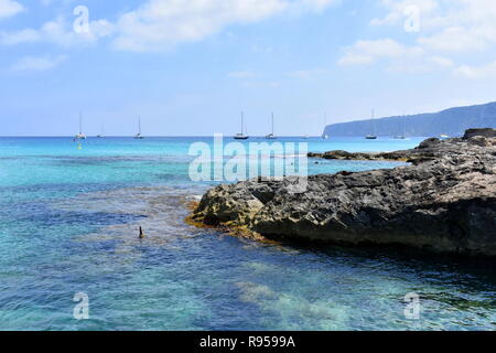 Bateaux ancrés au large de l'estran rocheux de Es Calo, Majorque, îles Baléares, Espagne Banque D'Images