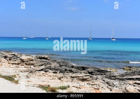 Bateaux ancrés au large de l'estran rocheux de Es Calo, Formentera, Espagne Banque D'Images