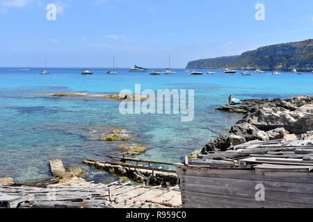 Fishermens ramshackle voile remises et les bateaux ancrés au large de Es Calo, Majorque, îles Baléares, Espagne Banque D'Images