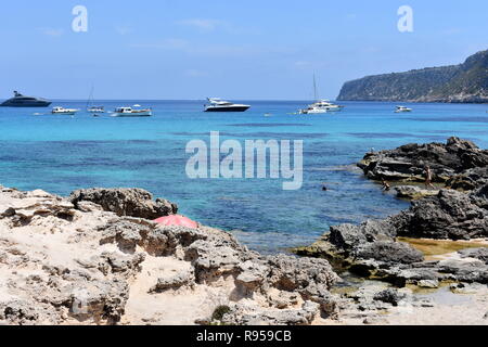 Personnes jouant dans la mer et les bateaux à l'ancre au large de Es Calo, Majorque, îles Baléares, Espagne Banque D'Images