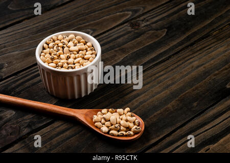 Black-eyed beans dans pot. Fond noir en bois. Banque D'Images