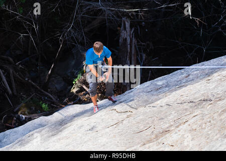 Le 11 février 2018 Los Gatos / CA / USA - Climber rappelling après l'ascension d'une paroi rocheuse à la cascade à Castle Rock State Park, Santa Cruz mountain Banque D'Images