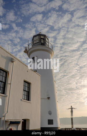 Le phare à Scarborough avec un mémorial la figure avec les bras tendus en avant. Il y a un ciel bleu au-dessus de la rupture du nuage. Banque D'Images