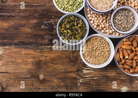 Composition des différents types de légumineuses dans des bols sur fond de bois Banque D'Images