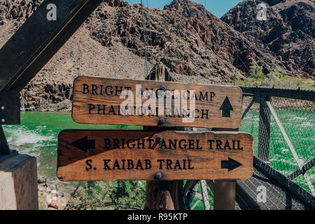 Un couple de sentier en bois panneaux sur le Bright Angel pont par la rivière Colorado vert dans le Grand Canyon au Parc National du Grand Canyon en Arizona, États-Unis Banque D'Images